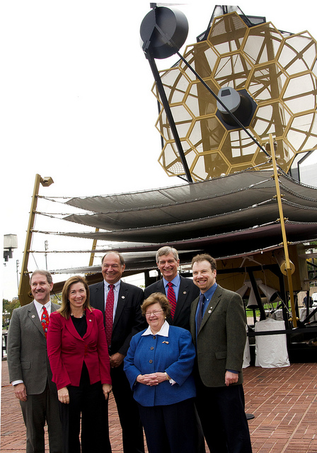 Senator Barb är damen i blått, här med idel NASA-toppar framför en fullskalemodell av The James Webb Telescope - längst t h nobelpristagaren Adam Reiss. Foto: Northrop Grumman/NASA