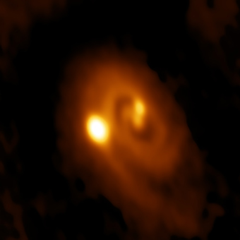 ALMA image of the L1448 IRS3B system, with two young stars at the center and a third distant from them.